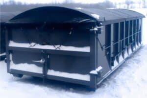 Image of a blue snowy roll off dumpster with a tarp covering it