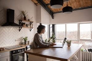 a woman working on her laptop in a kitchen