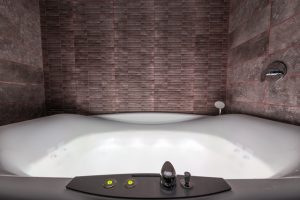 a white jacuzzi tub in a bathroom with a brick wall