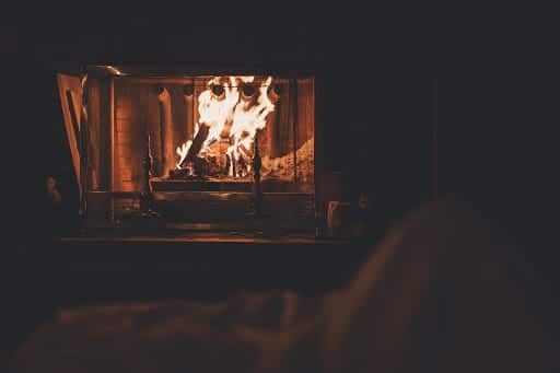 a person is sitting in front of a fireplace
