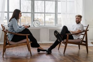 two people sitting in chairs talking