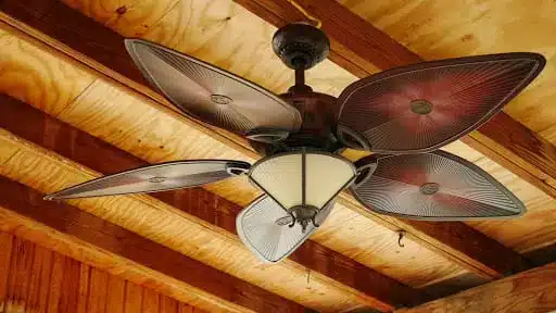a ceiling fan hanging from a wooden ceiling