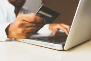 a man is using a credit card on a laptop