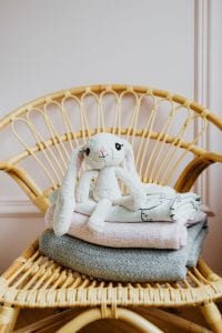 a stuffed bunny sitting on a wicker chair