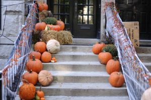 a house with pumpkins on the steps
