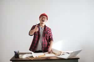 a man is standing at a desk with a laptop