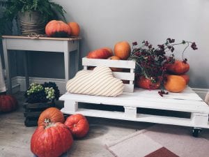 a white pallet with pumpkins and flowers on it