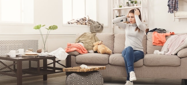 a frustrated woman starting to declutter a living room