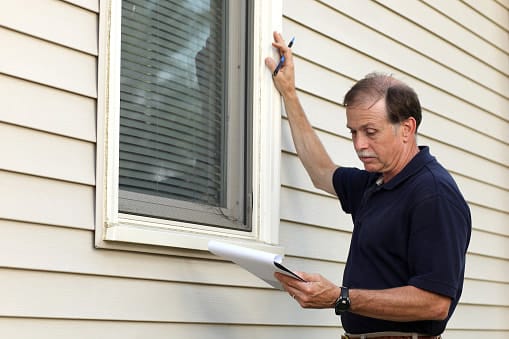 man inspecting an exterior residential window