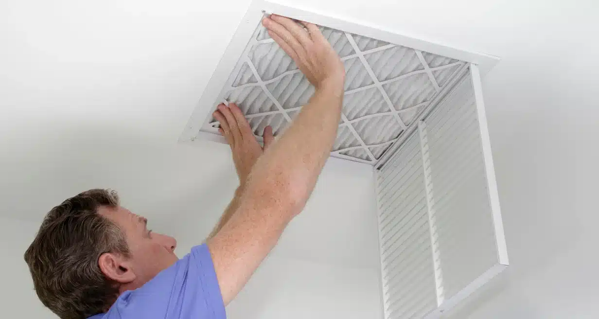 image of a man changing the HVAC filter